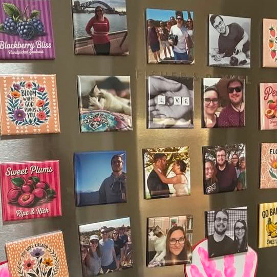 A refrigerator door covered with small square magnets featuring colorful text designs and several custom photo magnets.